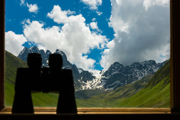 Big black binoculars lying on sill overlooking mountain.