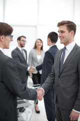 Two businessmen handshaking, congratulating on promotion.