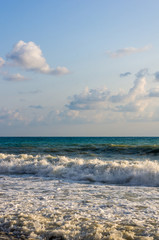 sea landscape is a pebbly beach with waves in white foam