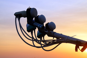 Silhouette of three satellite antenna heads at sunset