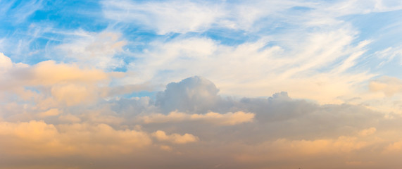 Panorama of cumulus clouds at sunset with gradient sky.