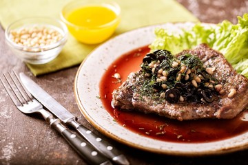 Veal with pine nuts and olives in red wine