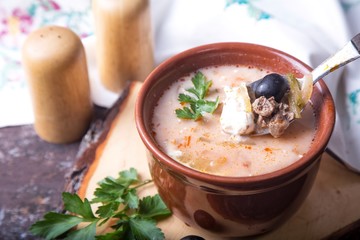  Solyanka. Soup with meat, olives, herbs, lemon, sour cream in bowl