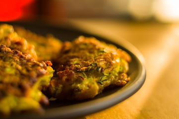 Fried vegetable fritters with zucchini, carrots, herbs, eggs, and cheese.