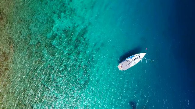 Yacht in amazing clear sea, taken from top in 4k by drone