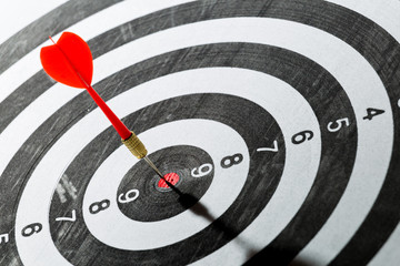dart arrow hitting in the target center of dartboard. concept of the success