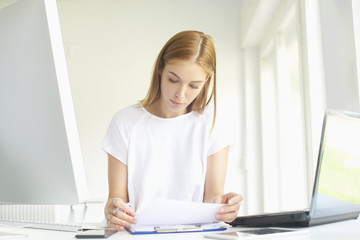 Confident young businesswoman working at office desk. Home office 