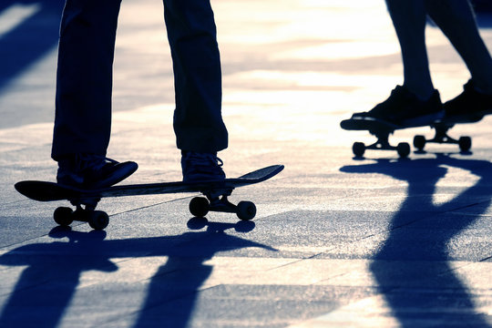 silhouette of people riding on a skateboard in the sun
