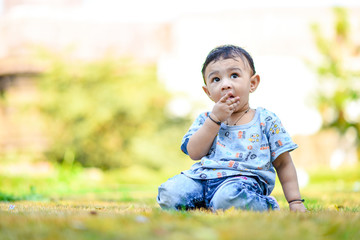 cute indian baby boy playing at garden