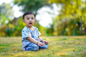 cute indian baby boy playing at garden