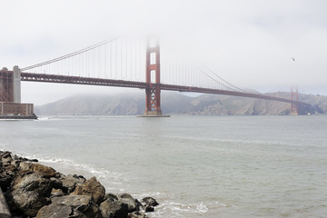 Cloudy midday in Golden Gate Bridge, seen from Marine Drive. The Golden Gate Bridge is a famous suspension bridge connecting the American city of San Francisco, California to Marin County.