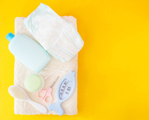 Baby bathing accessories, diaper, yellow background
