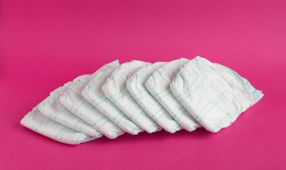 Baby diapers on a pink background, diaper - obrazy, fototapety, plakaty
