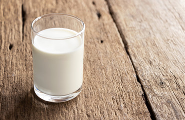 A glass of milk on the wooden table.