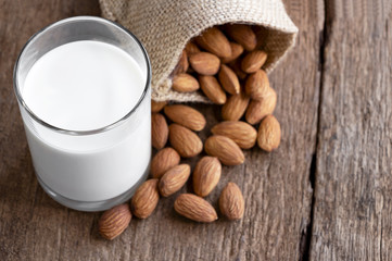 Almonds and a glass of milk on the wooden table.