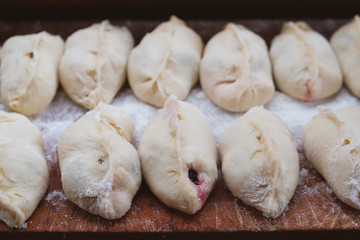 Vareniki, dumplings on wooden board, traditional Ukrainian and Russian dish.
