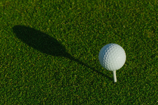Golf ball on the green course. Close up. Top view. Sport, relax, recreation and leisure concept