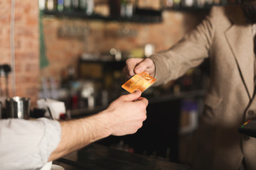 Bartender accepting credit card at bar counter
