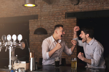 Excited friends emotionally cheering for favorite team