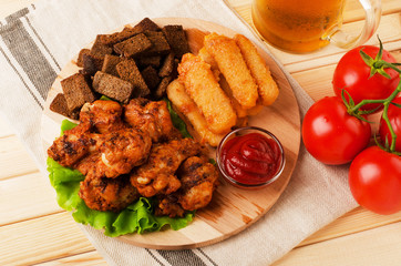 Fried wings, dried bread and cheese sticks with mug beer, served with sauces