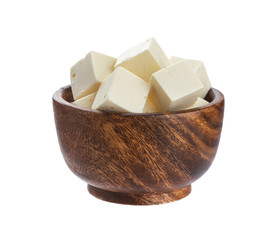 Greek feta cubes in wooden bowl. Diced soft cheese isolated on white background