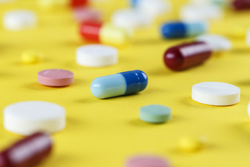 pills are scattered on a yellow background