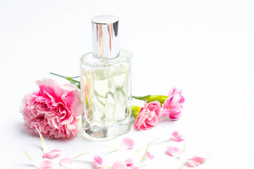 Obraz na płótnie Canvas Perfume bottles and pink carnations on white background