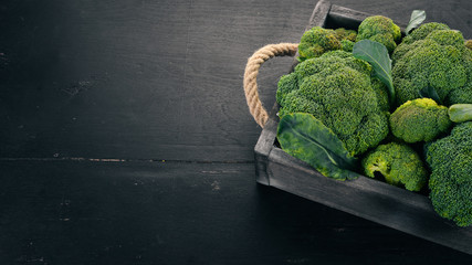 Broccoli in a Wooden box. Healthy food. On a wooden background. Top view. Copy space.