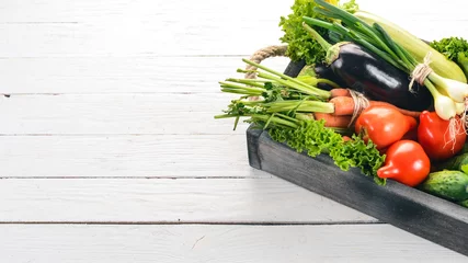 Keuken spatwand met foto A set of fresh vegetables in a wooden box. On a wooden background. Top view. Copy space. © Yaruniv-Studio