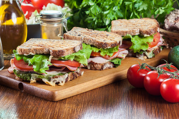 Sandwiches with ham, cheese, tomatoes, lettuce and cucumber
