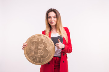 Studio portrait of business lady in red suit with bitcoin showing thumbs up.