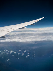 Obraz premium View from airplane window with blue sky and white clouds, background for travel holiday trip, Aircraft on the sky.
