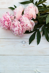 Peonies on a white wooden background with copy space