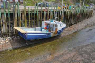 Obraz premium View of Halls Harbour, Nova Scotia boat at low tide