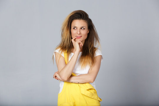 Headshot Of Tricky Beautiful Woman With Curly Long-hair Style Touching Lips, Looking Aside With Cunning Smile And Having Some Ideas In Her Mind. Attractive Female Having Sly Expression