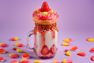 Freakshake. Extreme milkshake with strawberry, jelly sweets, donut.