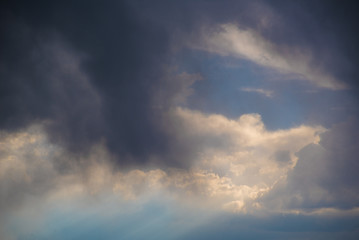 Obraz premium Rays of light shine through layers of storm clouds