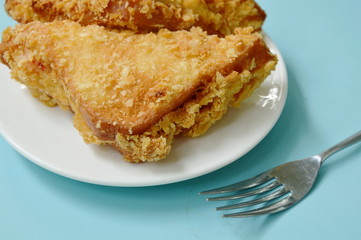 crispy fried sandwich stuffed tuna and imitation crab stick on white plate