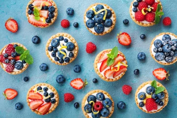 Wall murals Dessert Colorful berry tartlets or cake for kitchen pattern. Pastry dessert from above.