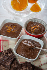 close up of dark chocolate mousse with tablets and oranges