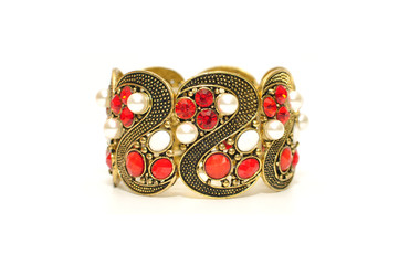 Big wide antic gold bangle with red gem rhinestone and white pearl isolated on white background