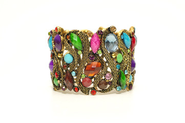 Big wide antic gold bangle with colorful gem and rhinestone isolated on white background