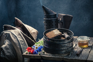 Hats, fresh honey with honeycombs and beekeeper tools