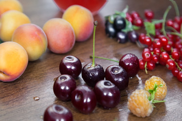 Ripe Blackcurrants, Cherries, Red Currants,Apricots. Still Life with Colorful Berries. Wooden Table. 