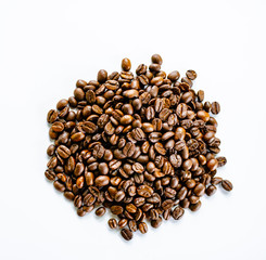 Roasted coffee beans pile on white background a view from the top.