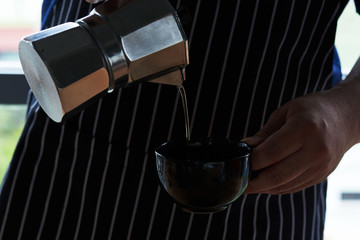 A man pouring coffee from a pot