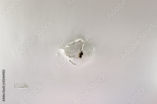 A Hole In A Bathroom Ceiling Caused By Water Damage Rot