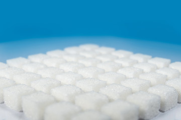 Table top shot Group of Sugar cubes vary position on light blue background