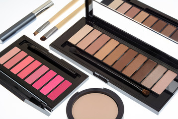 Collection of two cosmetics palettes for eye and lip makeup isolated. Vivid colorful tints, hot colors for face make-up. Lipsticks and eyeshadows kit. Mascara, brushes and powder. Side view.