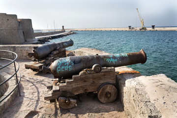 Fototapeta na wymiar Artillery cannon gun in front of Carlo V Castle in port Monopoli, Apulia, Bari province, Italy